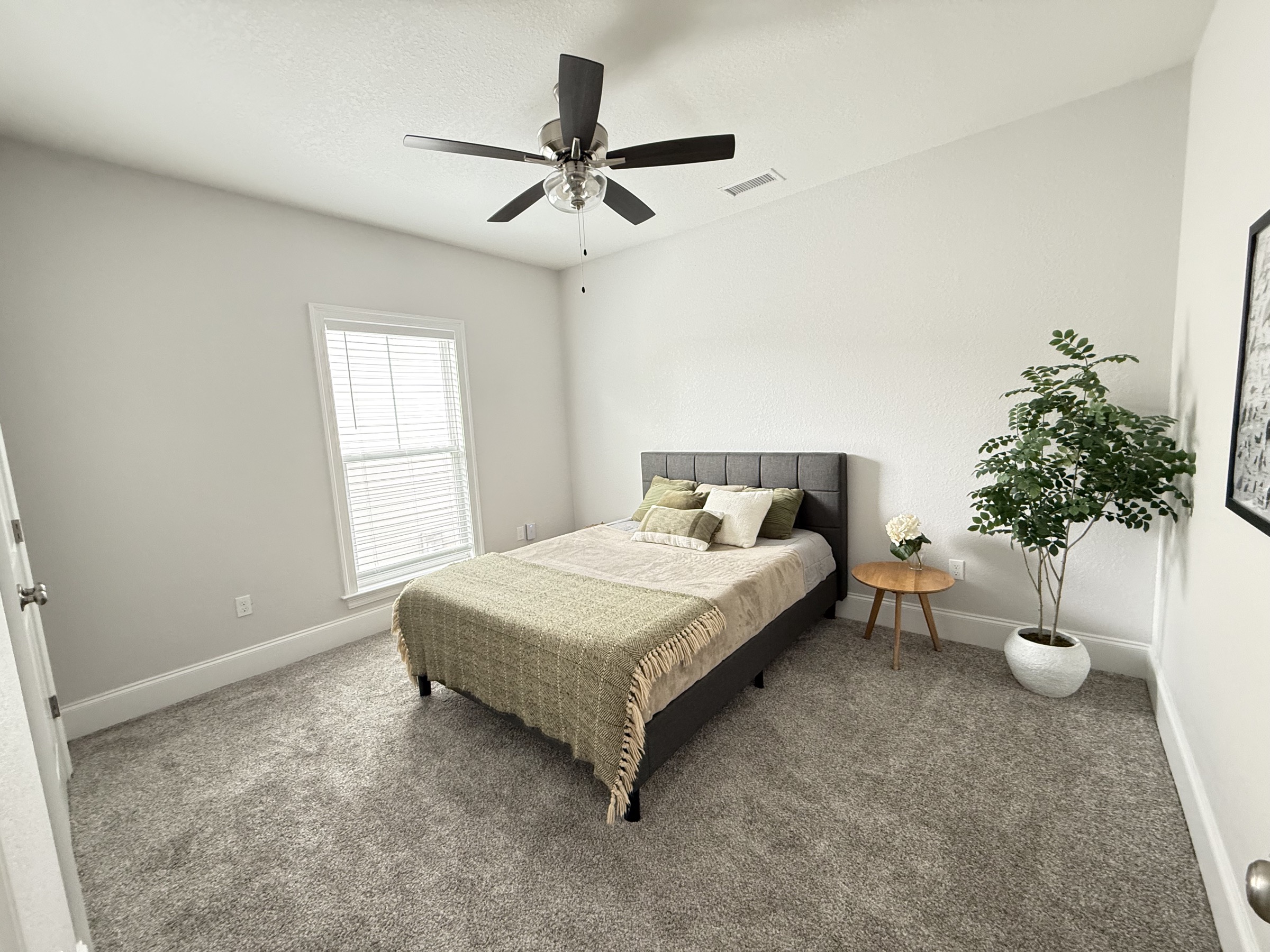 Secondary bedroom with hardwood floors and natural light