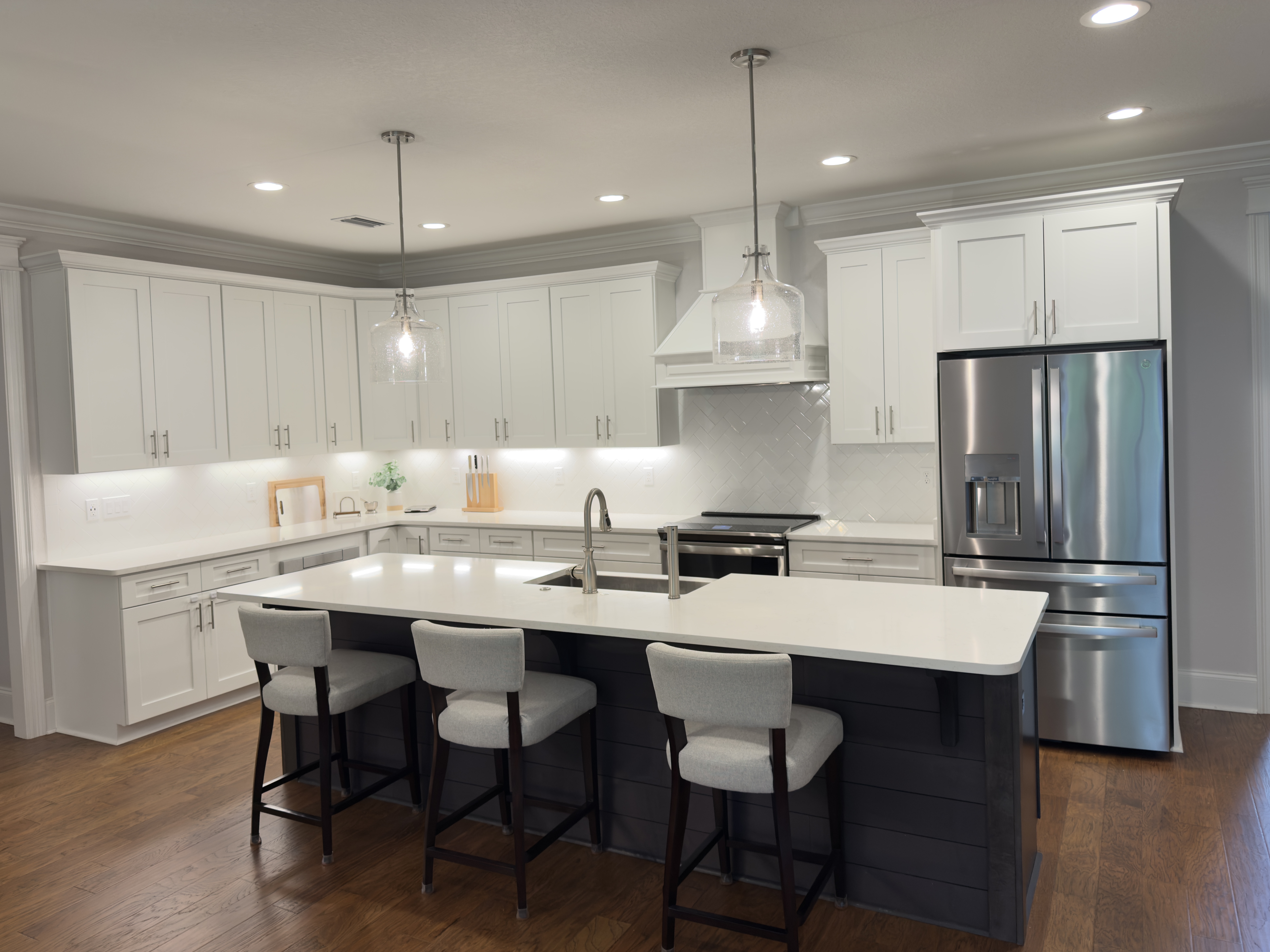 Open kitchen with white cabinetry, large island and stainless appliances