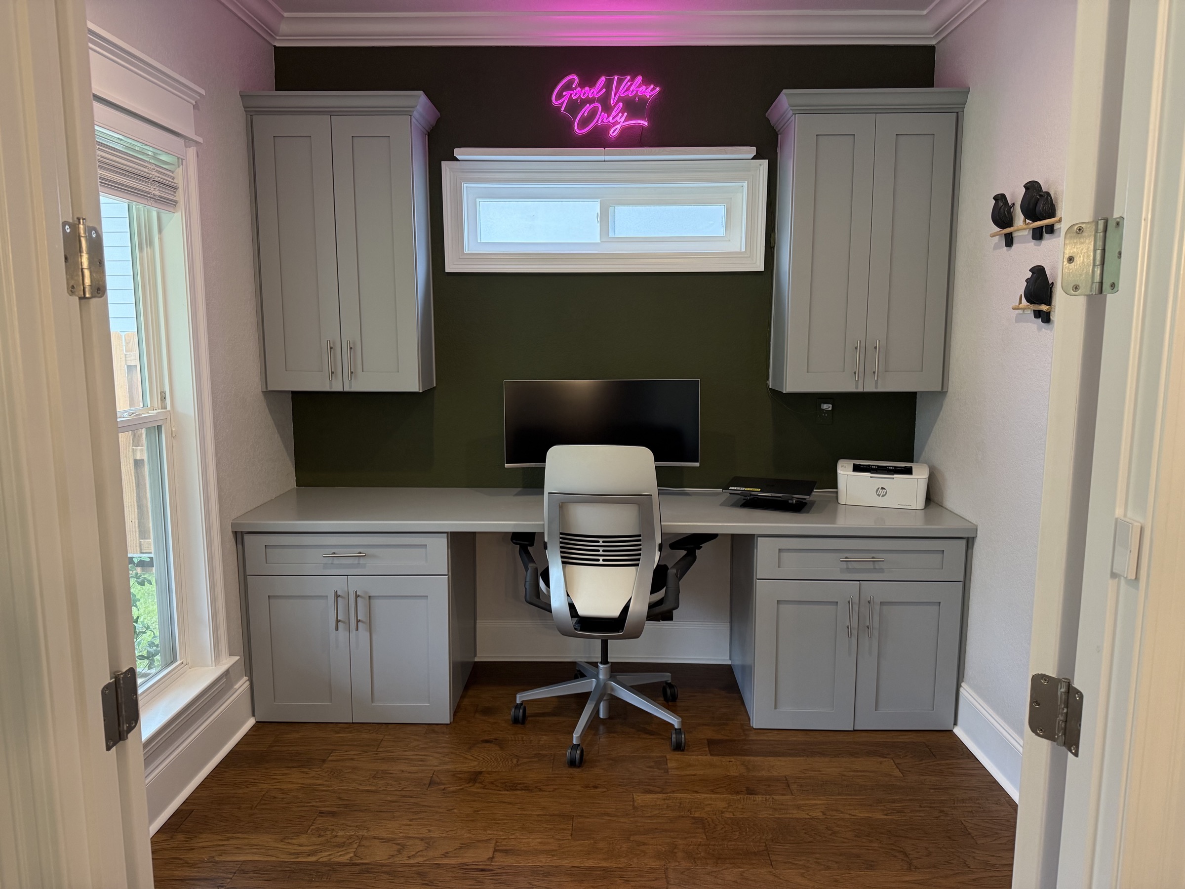 Dedicated office with built-in cabinetry, custom desk and accent wall