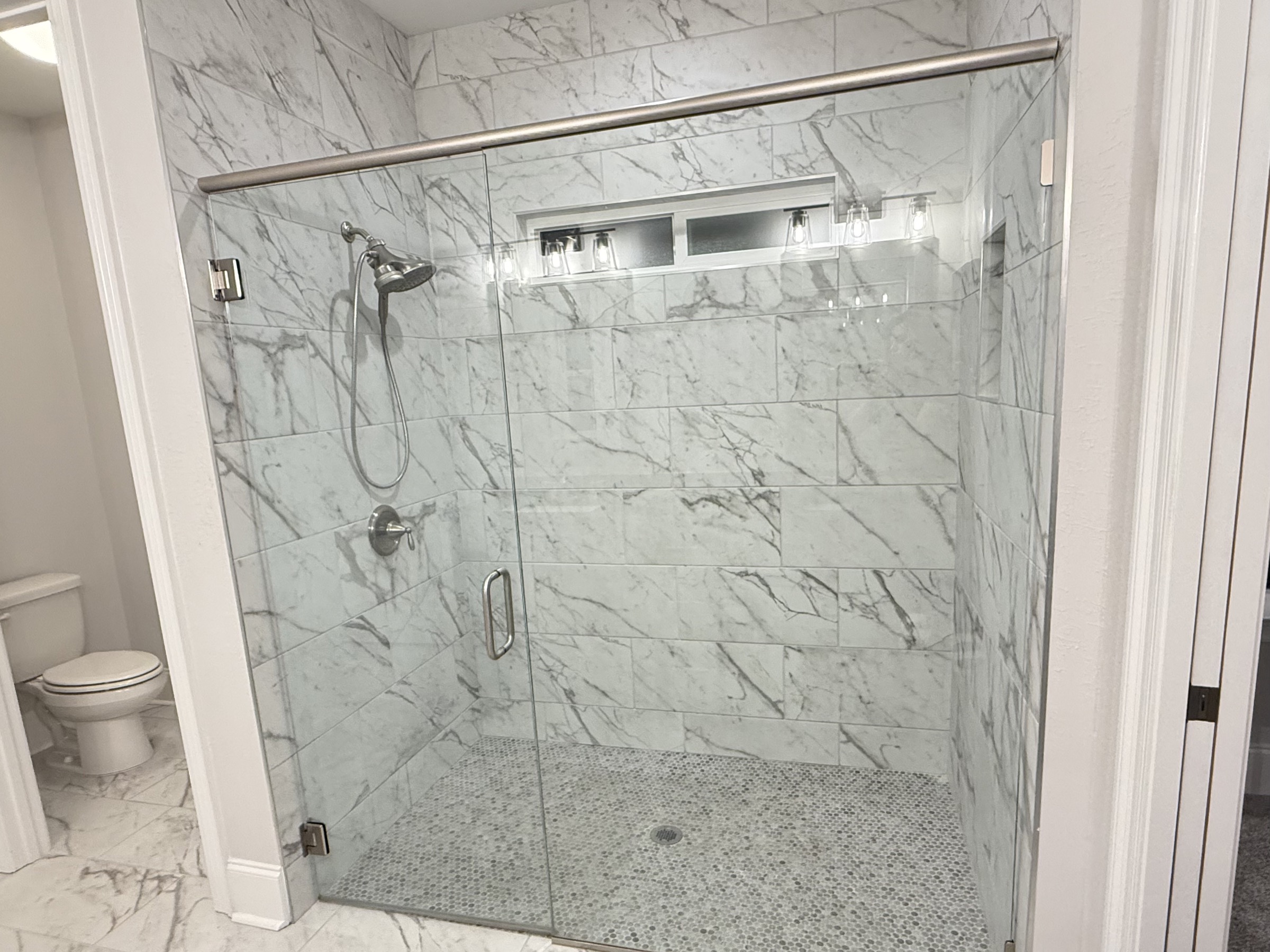 Primary bathroom shower with glass enclosure