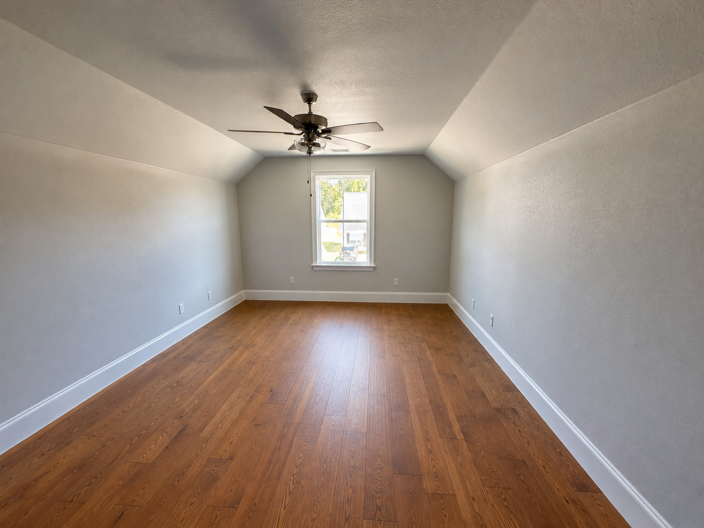 Third bedroom with hardwood floors, sloped ceiling and window
