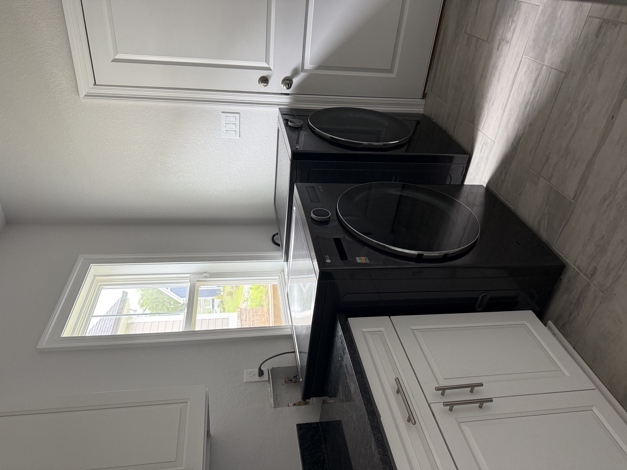 Laundry room with cabinetry and window