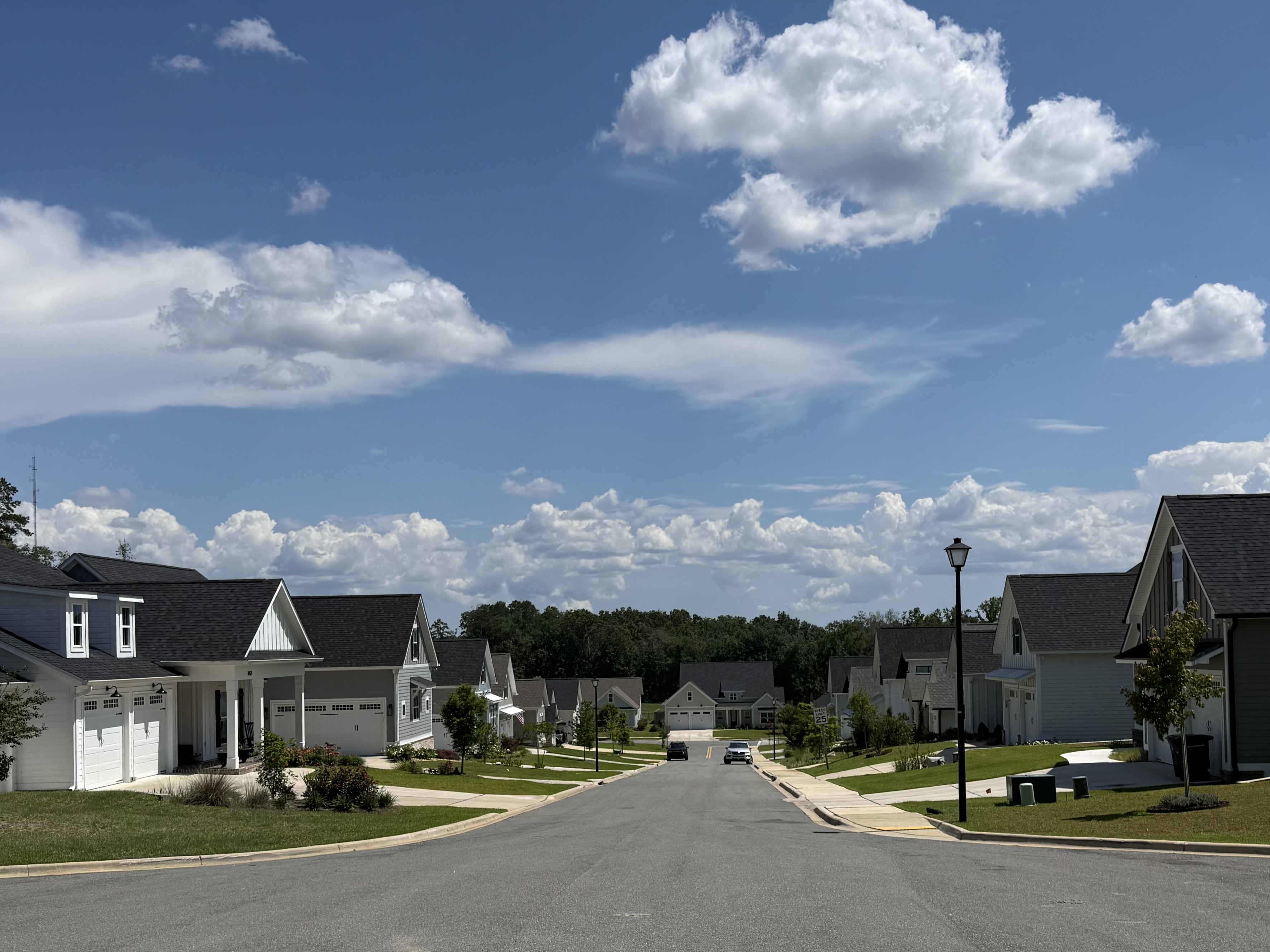Neighborhood street view with homes, sidewalks and open sky
